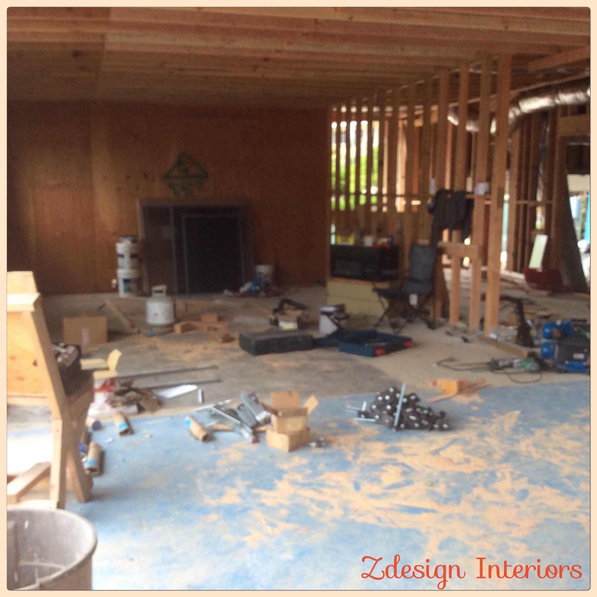 Interior renovation with exposed wood framing and the existing fireplace