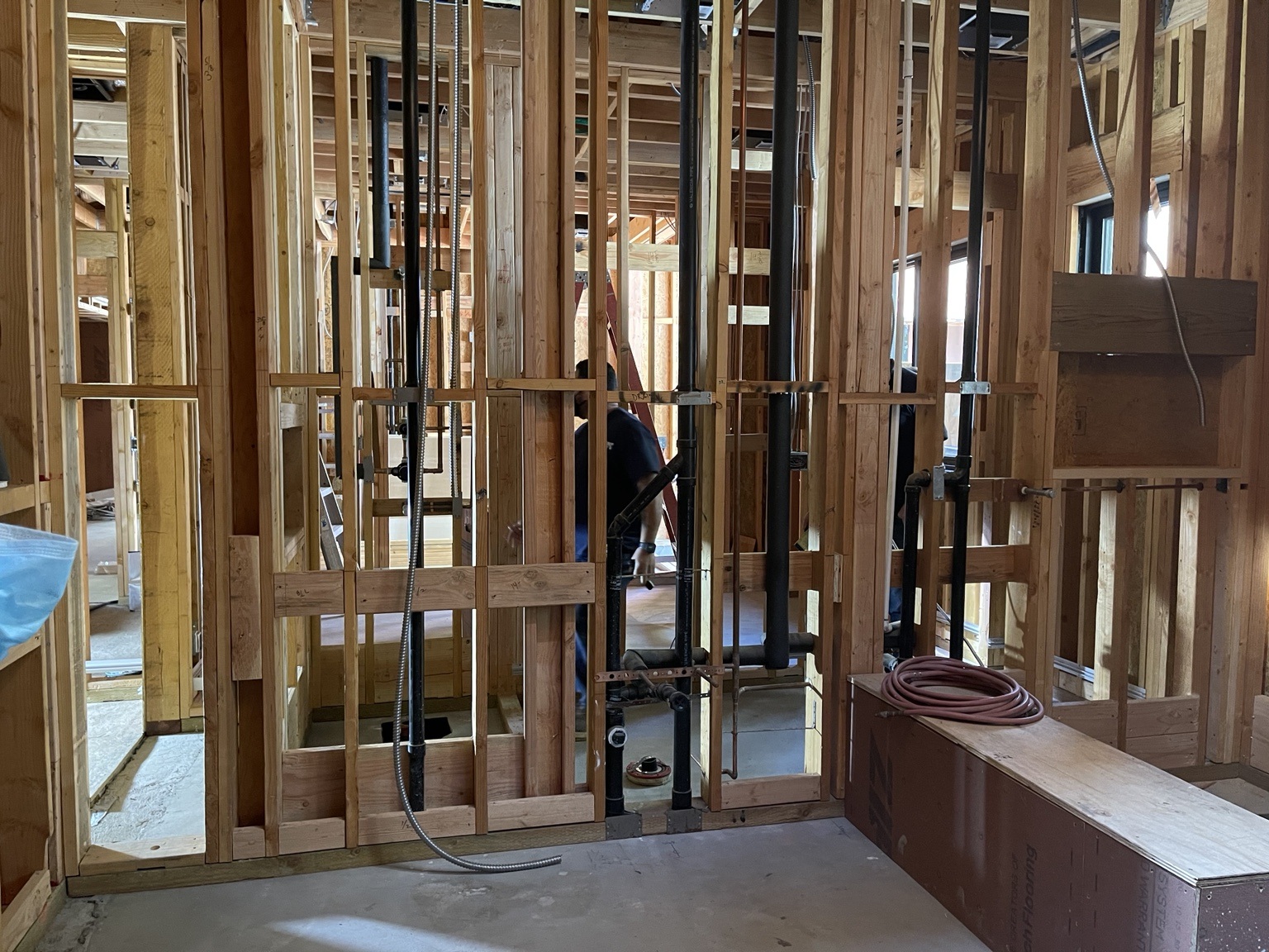 Bathroom wall framing with exposed plumbing and electrical services