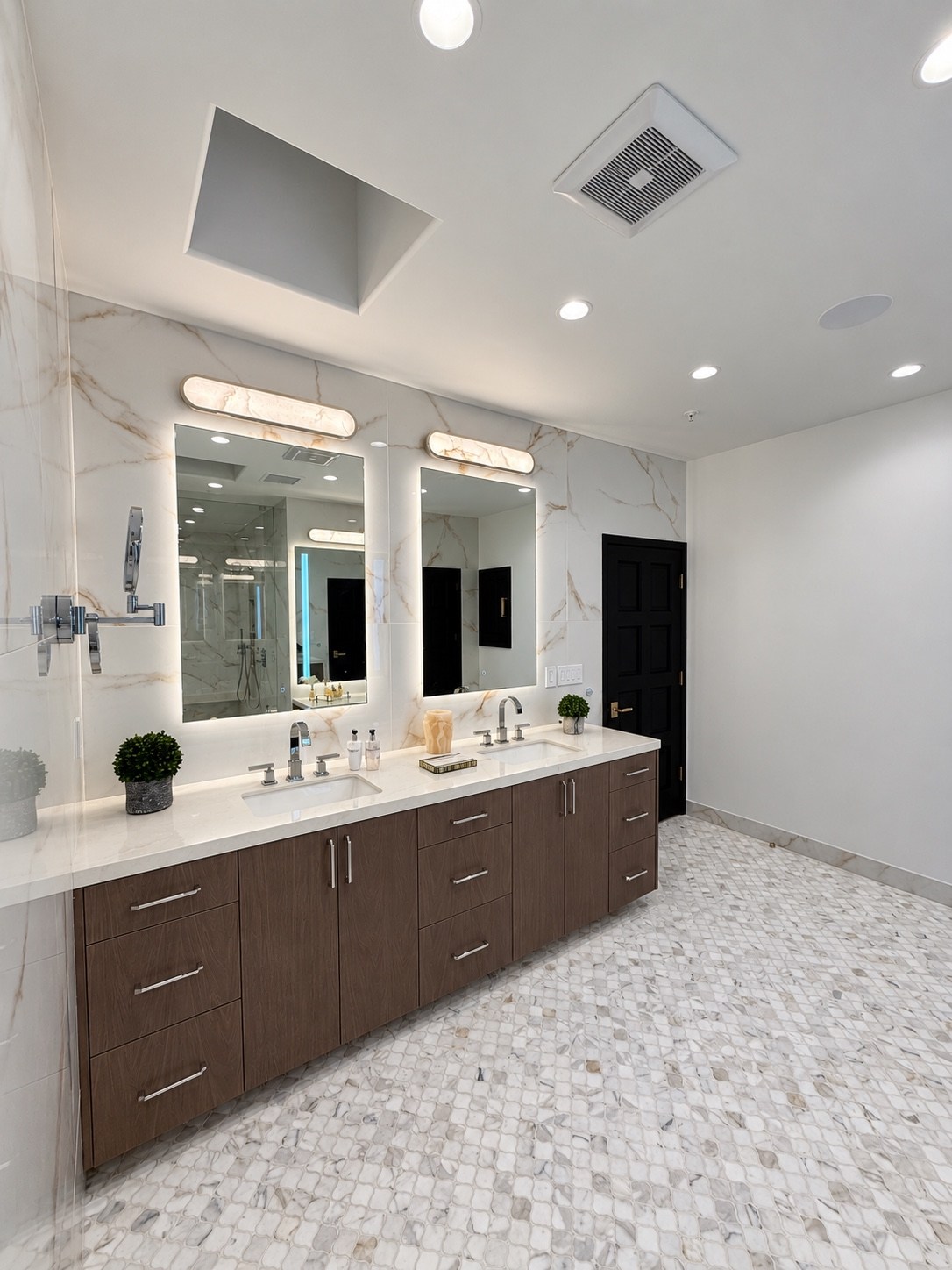 Double vanity with wood cabinetry and illuminated mirrors